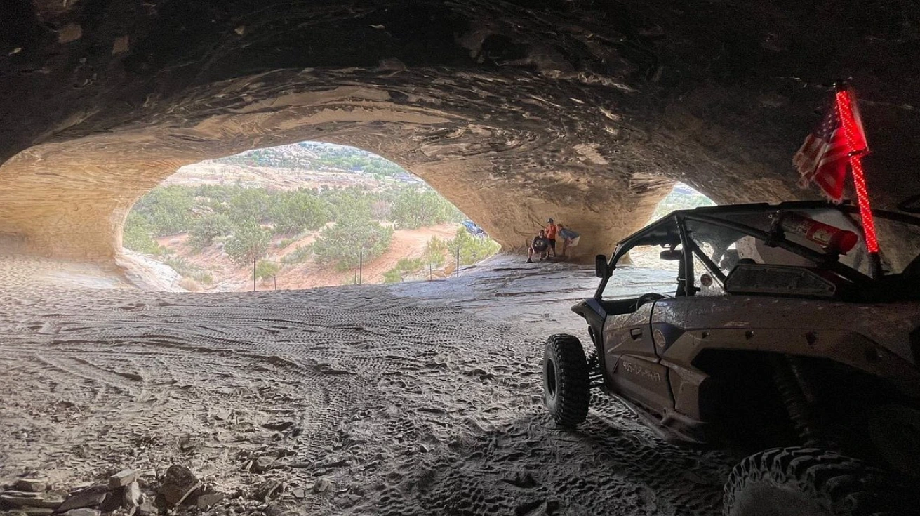 Side-by-side UTV parked inside a sandstone cave near Vernal Utah