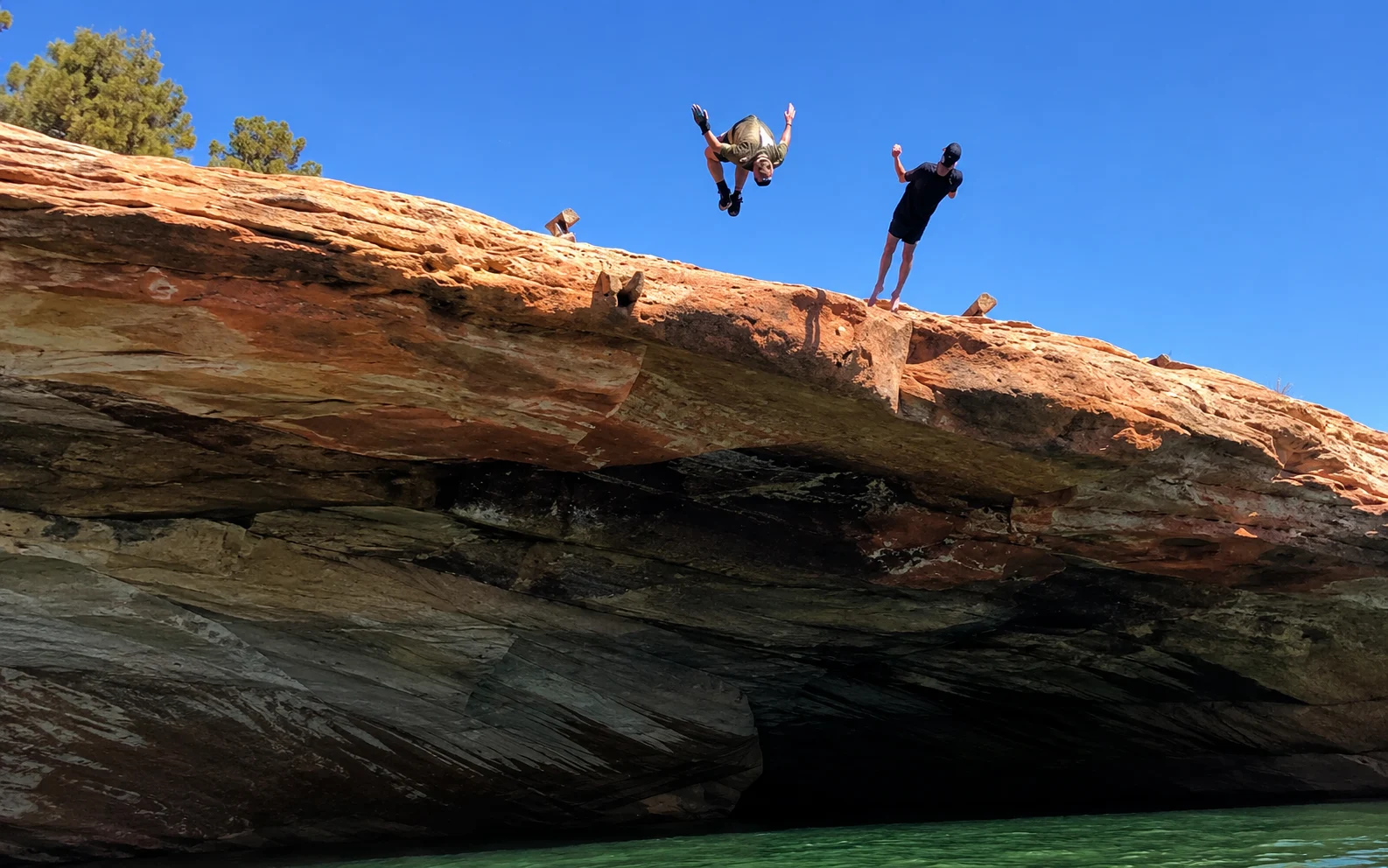 Rider leaping off a cliff into the water on an Adventure Tours Vernal outing near Vernal Utah