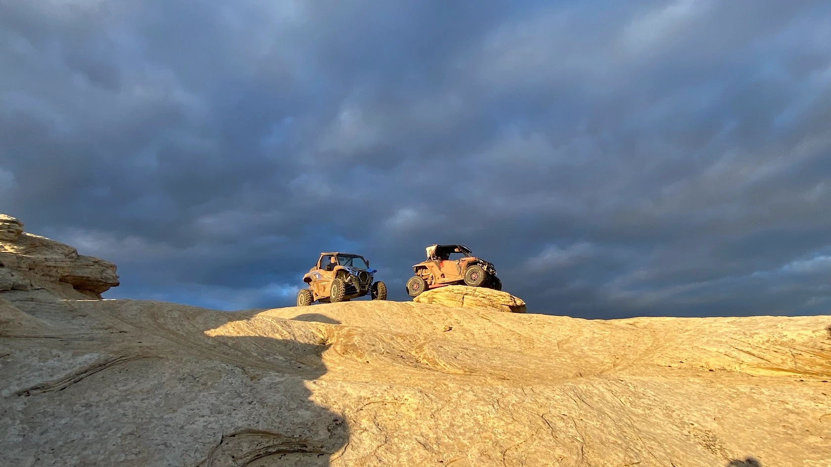 Two side-by-side UTVs parked on slickrock near Vernal Utah