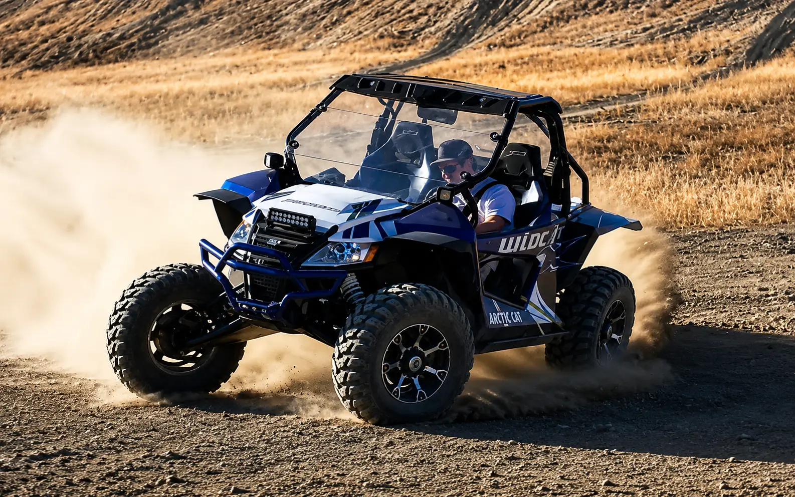 Blue side-by-side UTV kicking up dust on a desert trail near Vernal Utah