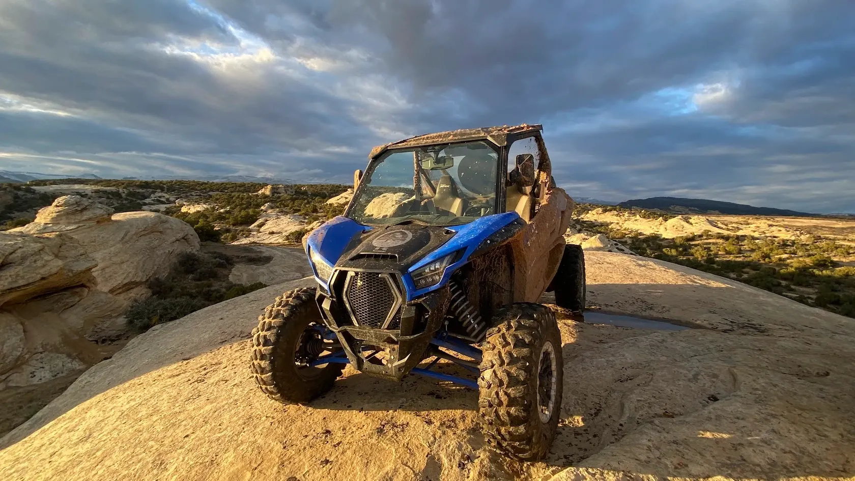 Blue side-by-side UTV on slickrock high above the canyon near Vernal Utah