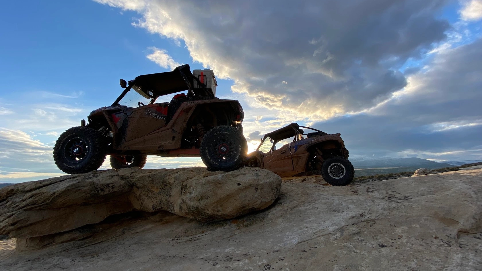 Side-by-side UTVs silhouetted at sunset on a guided tour near Vernal Utah