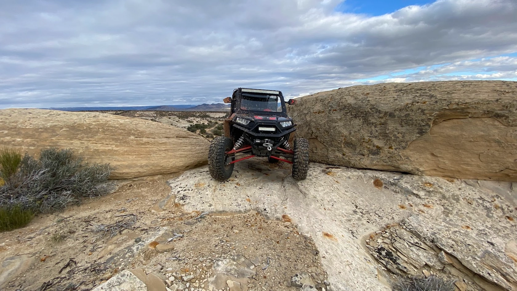 Side-by-side UTV descending a steep rock face on a guided tour near Vernal Utah