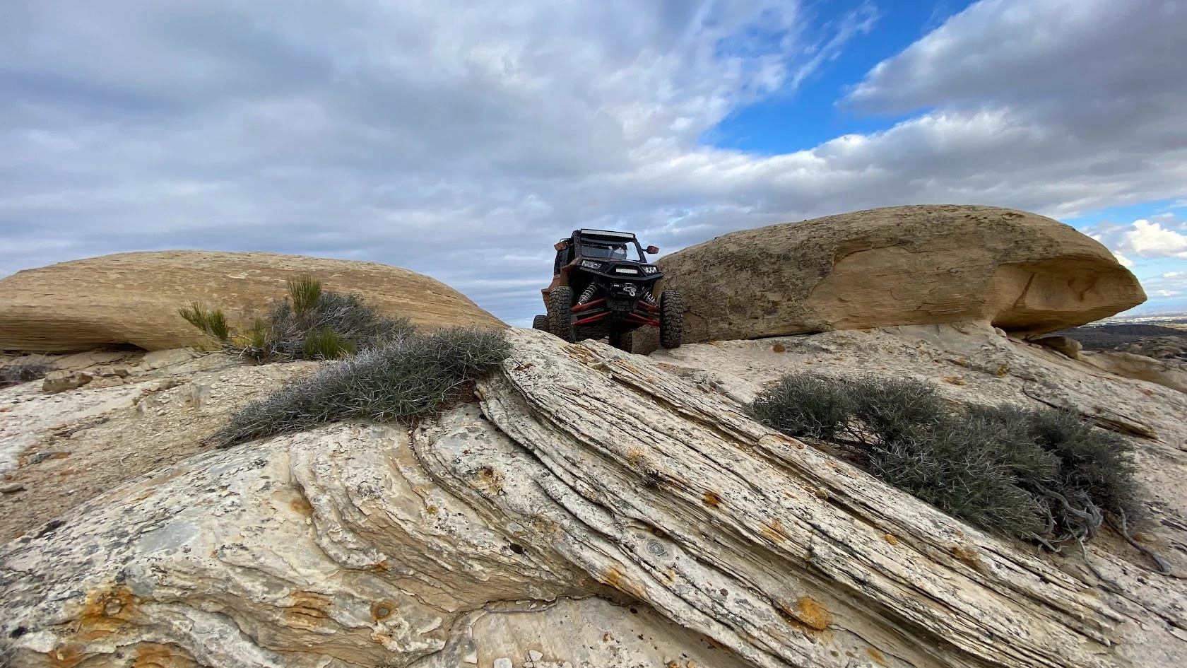 Side-by-side UTV cresting boulders on a backcountry trail near Vernal Utah