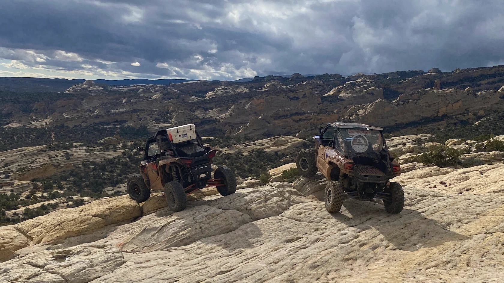 Side-by-side UTVs climbing slickrock on a guided tour near Vernal Utah