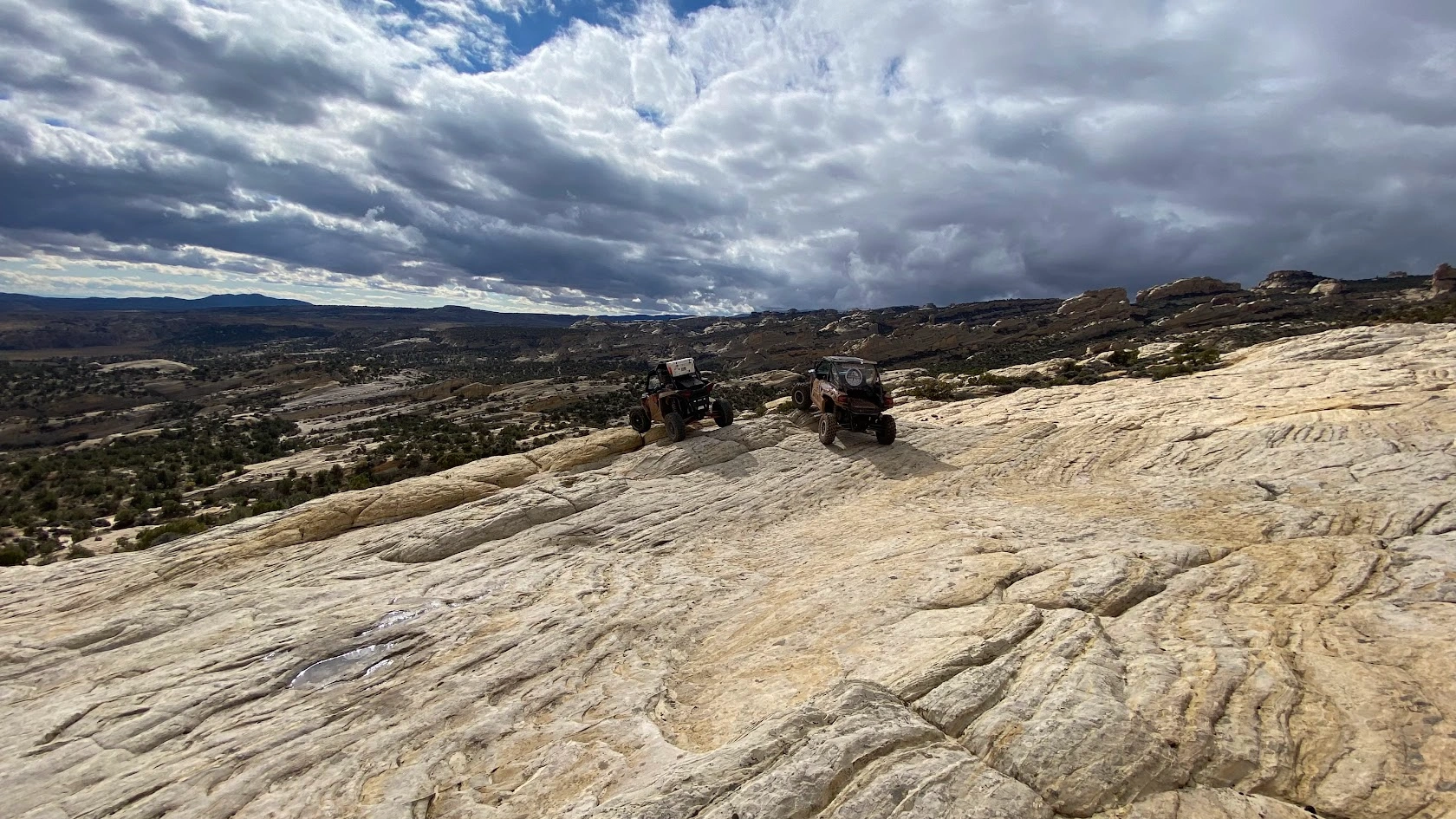 Side-by-side UTVs on the slickrock on a backcountry tour near Vernal Utah