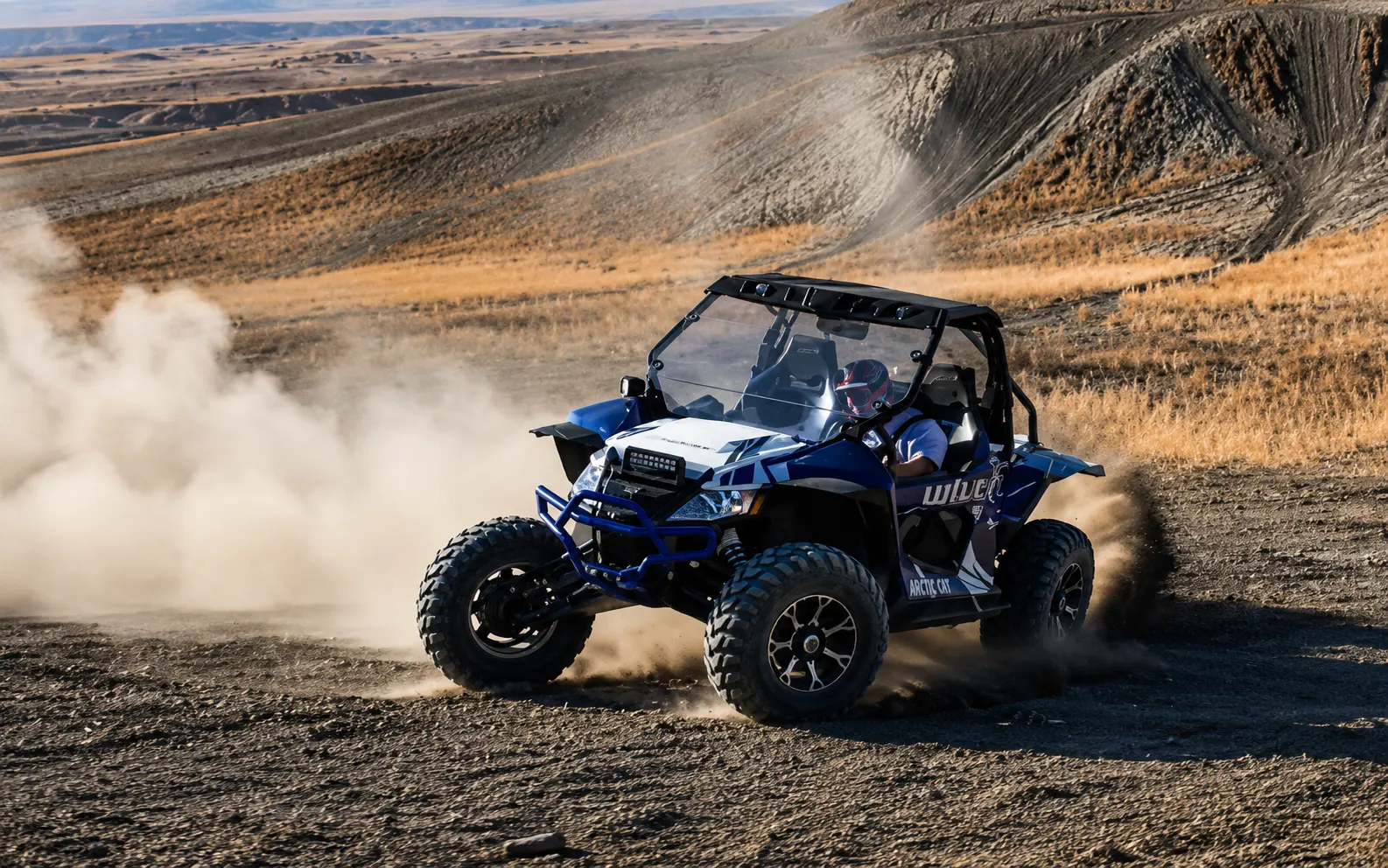 Blue side-by-side UTV kicking up dust on a desert trail near Vernal Utah