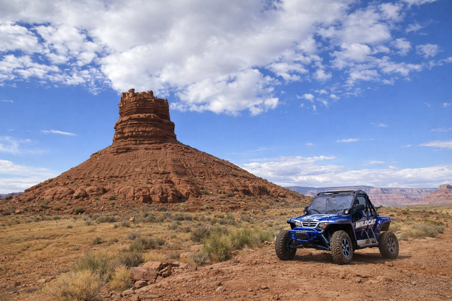 Side-by-side UTV parked below a desert butte near Vernal Utah