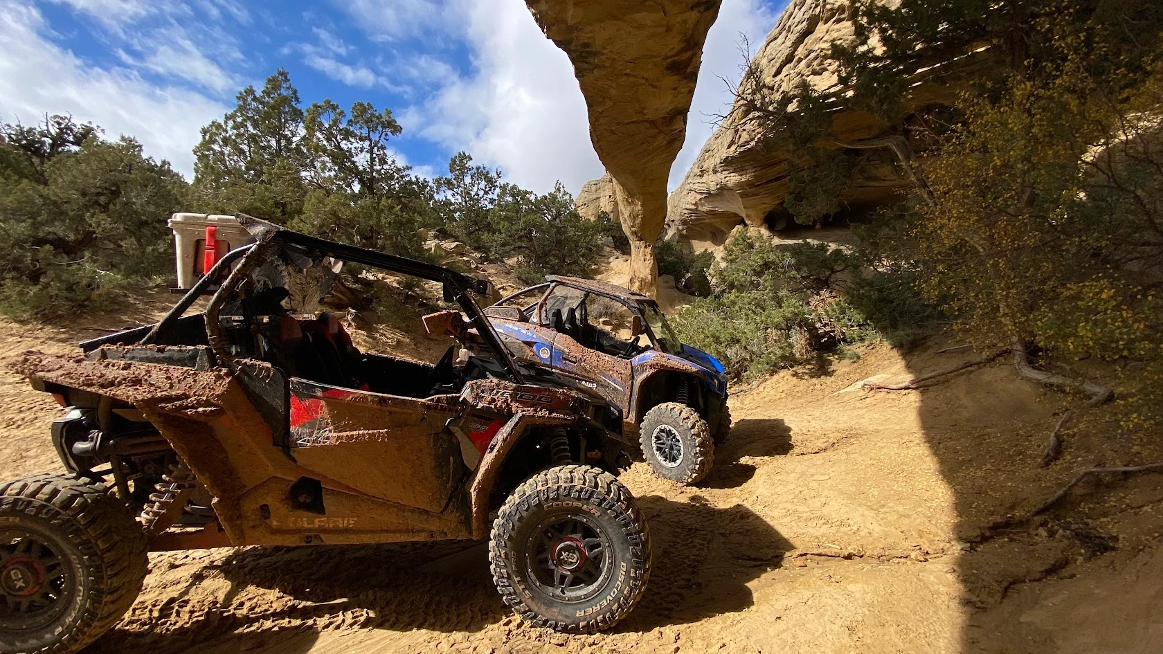 Muddy side-by-side UTV climbing rocks on a backcountry tour near Vernal Utah