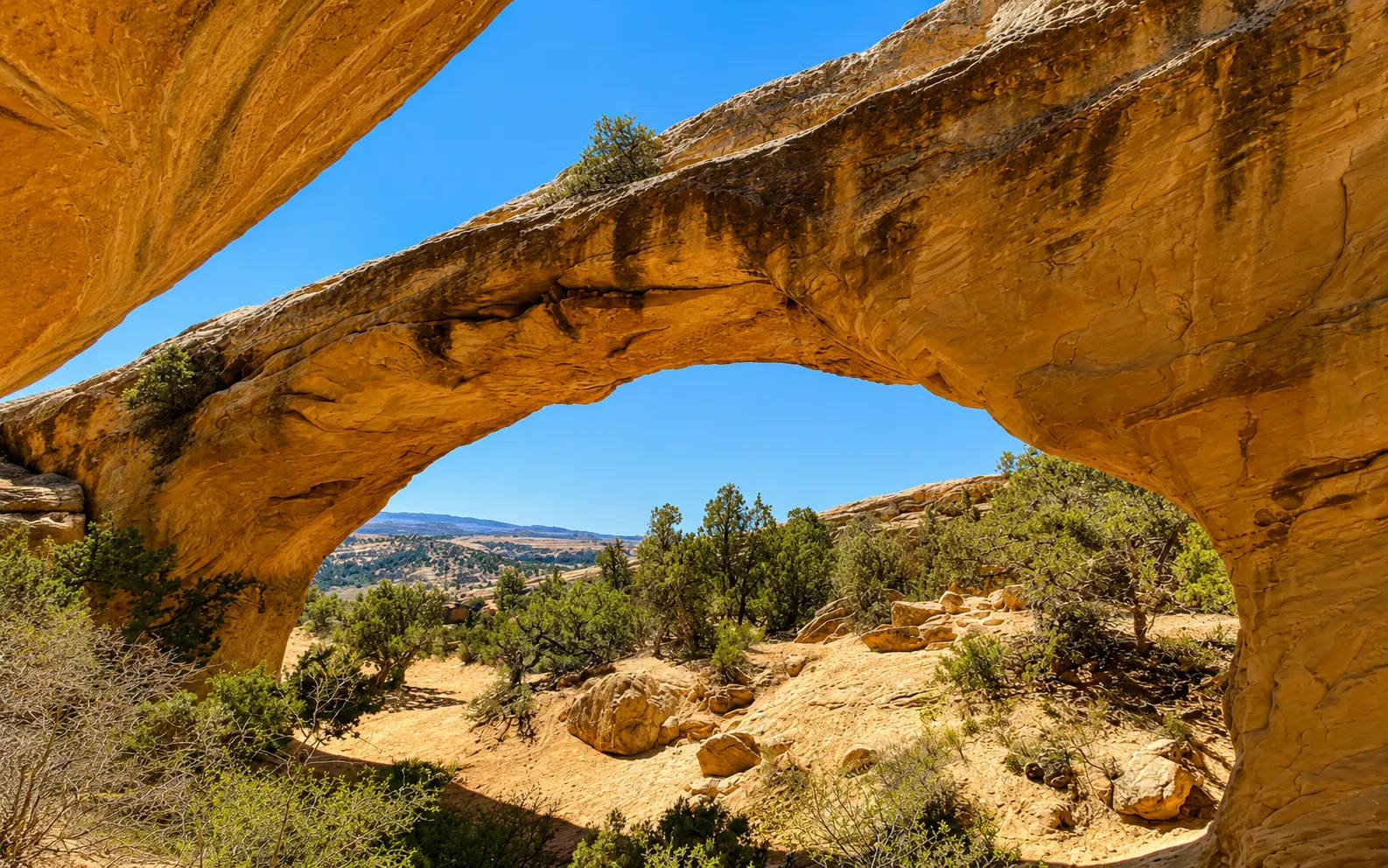 Large natural sandstone arch above the valley on a guided UTV tour near Vernal Utah