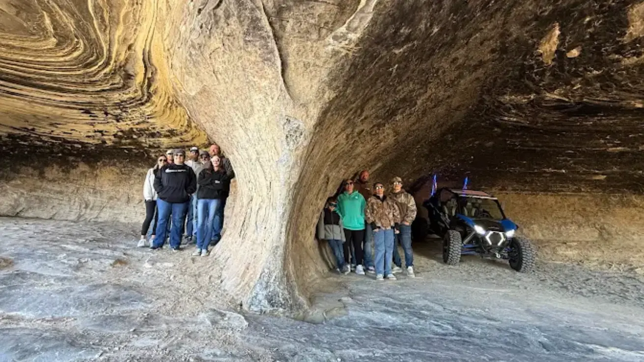 Looking out from inside a sandstone cave on a guided UTV tour near Vernal Utah
