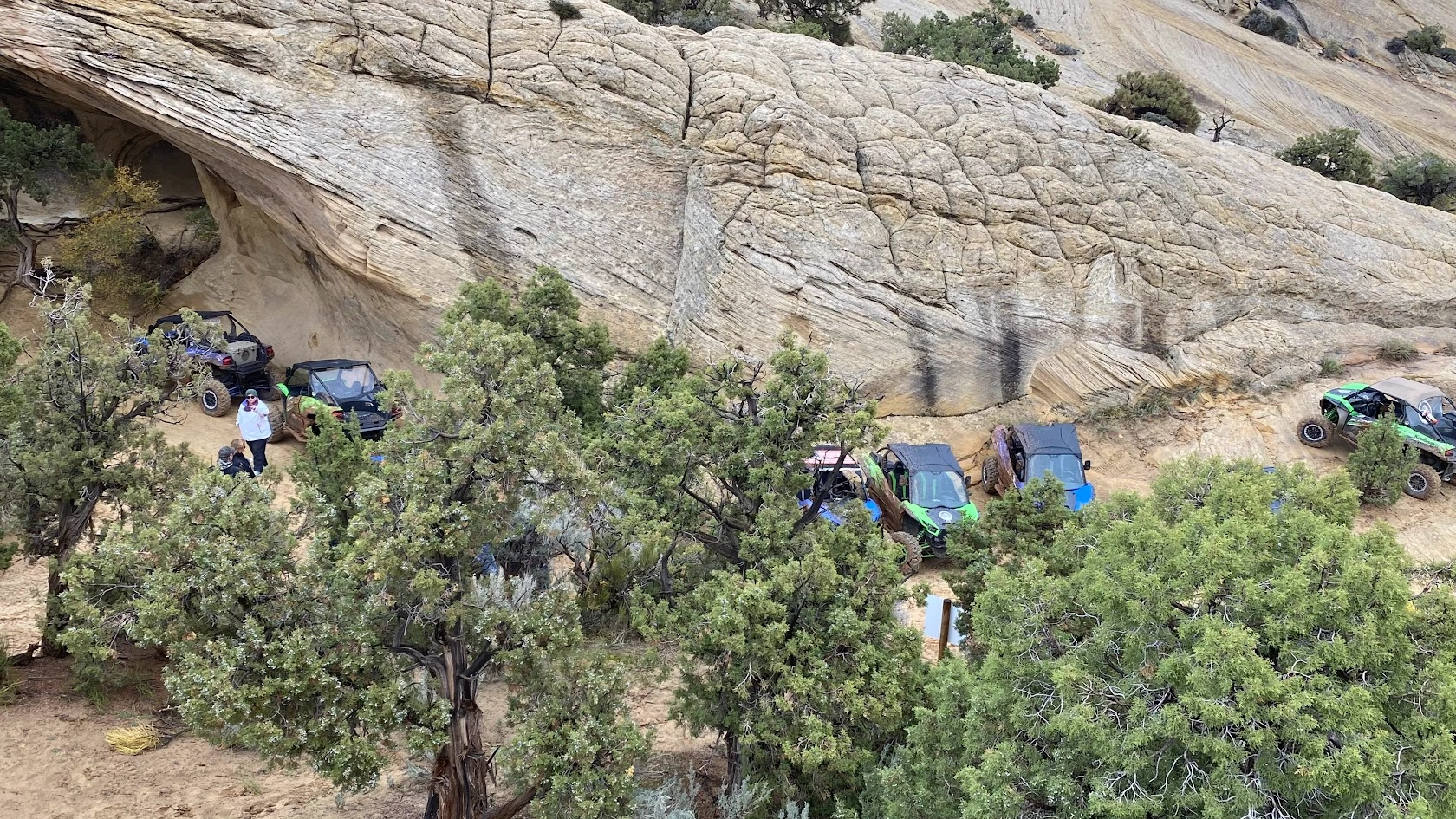 Side-by-side UTVs staged below a slickrock dome near Vernal Utah