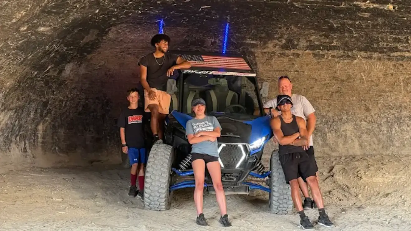 Family posing inside a sandstone cave on an Adventure Tours Vernal UTV tour