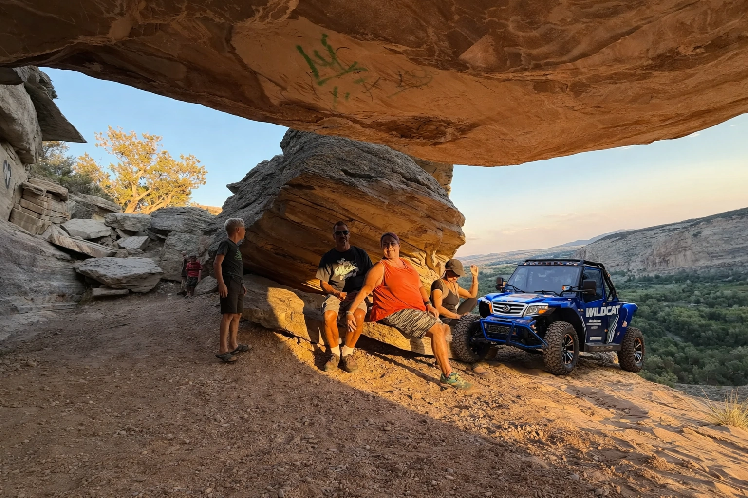Tour group at a rock arch at sunset near Vernal Utah
