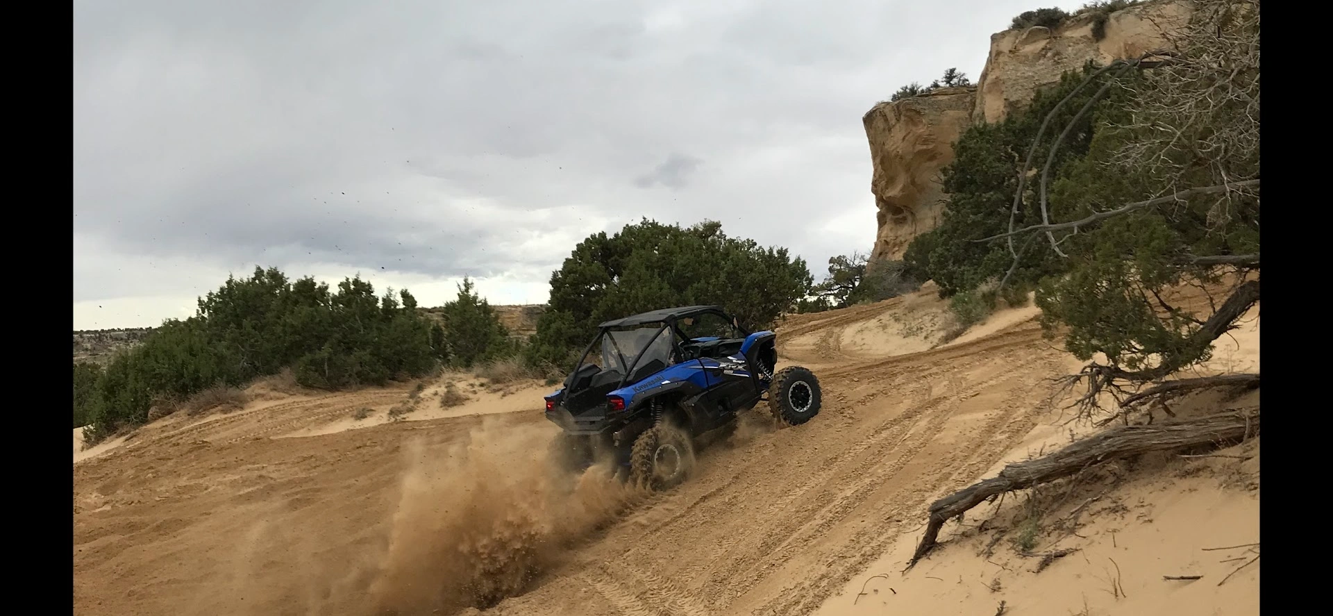 Side-by-side UTV sending it over a sand dune near Vernal Utah