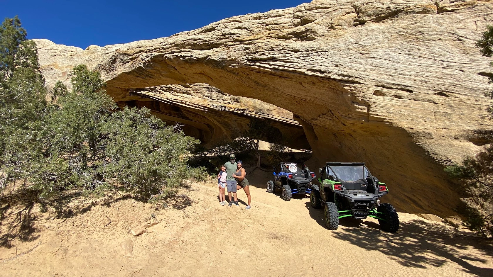 Side-by-side UTV parked beside a sandstone arch near Vernal Utah