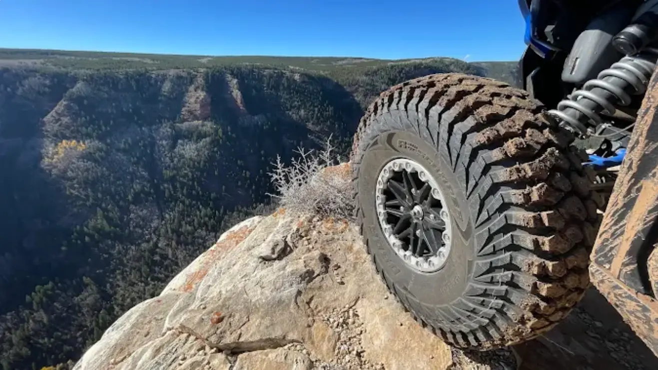 UTV tire perched on a canyon rim overlooking Ashley Gorge near Vernal Utah