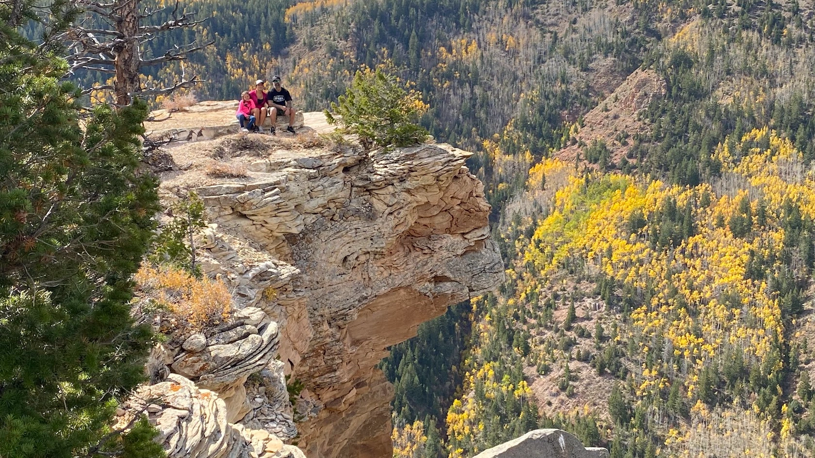 Couple posing at a cliff edge overlooking the canyon near Vernal Utah