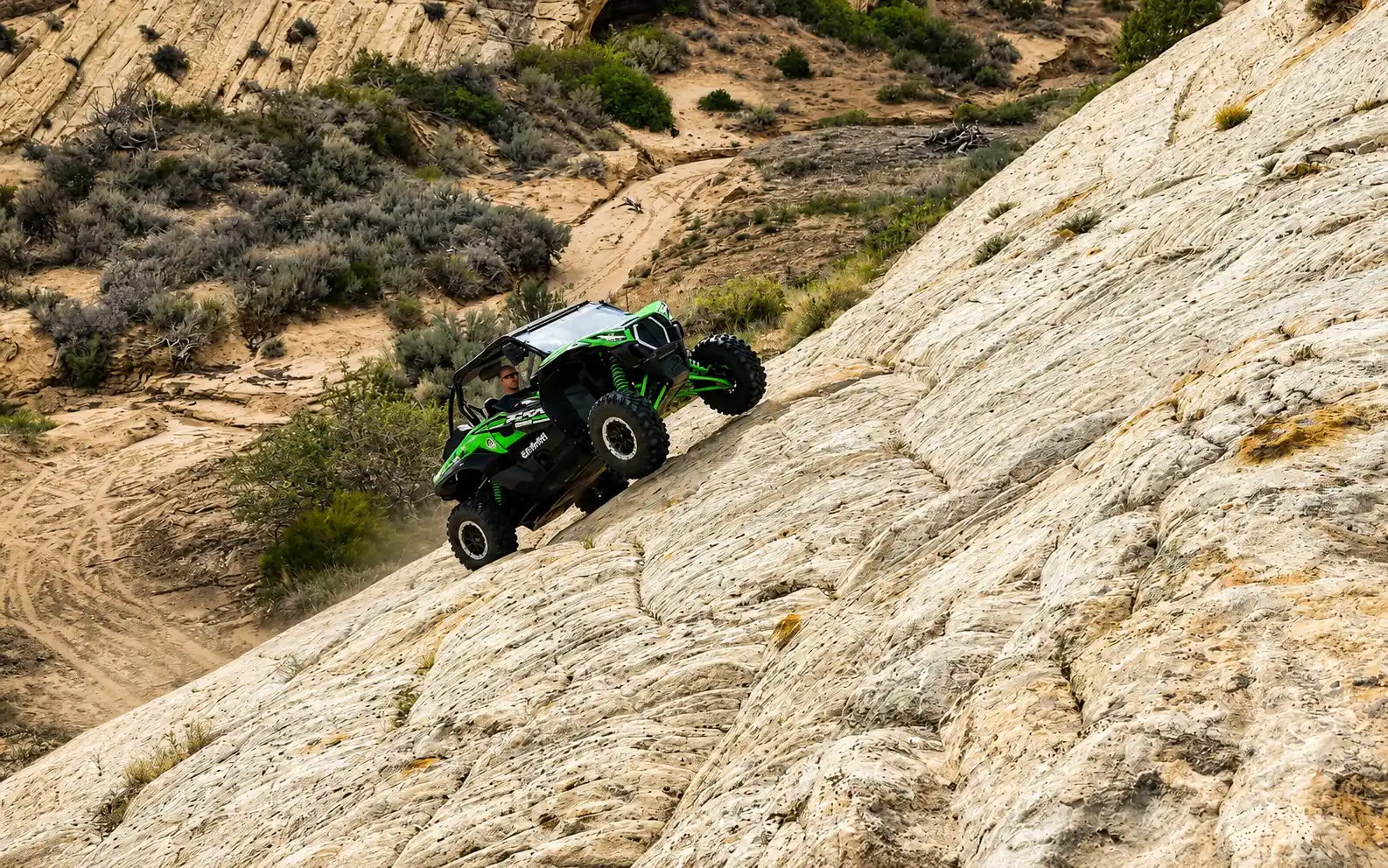 Side-by-side UTV on a slickrock descent near Vernal Utah
