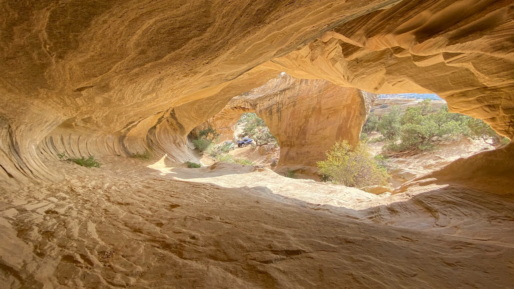 Inside a sandstone cave looking out a window opening near Vernal Utah