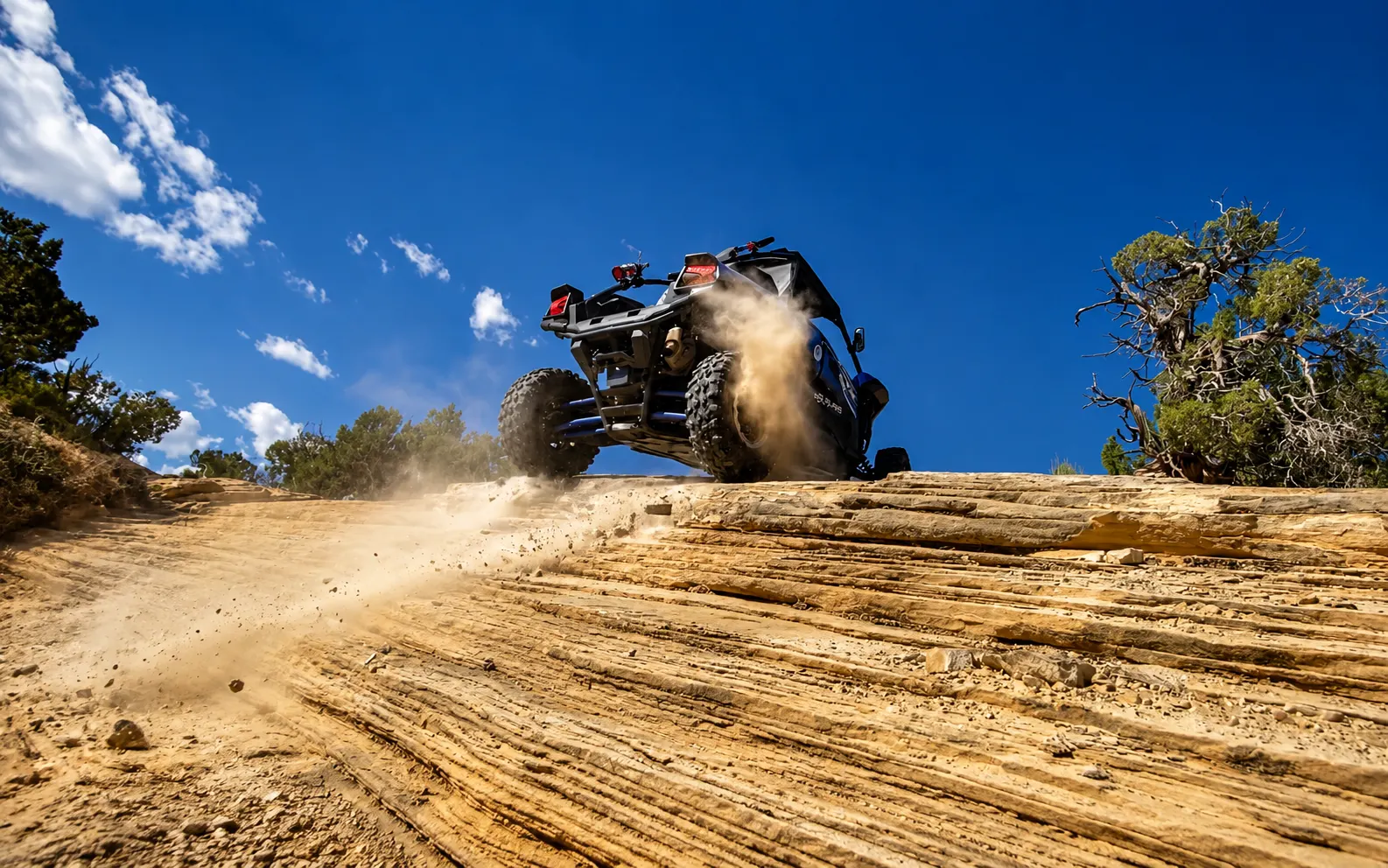 Side-by-side UTV throwing dust on a desert trail near Vernal Utah