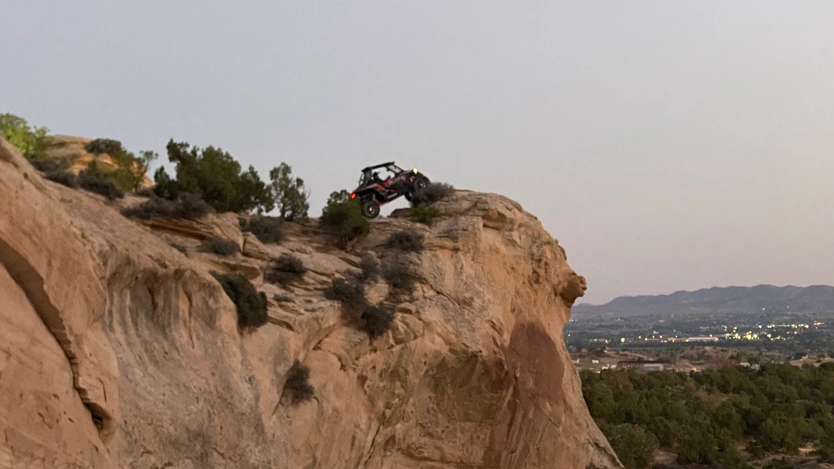 Side-by-side UTV at a cliff edge at dusk near Vernal Utah
